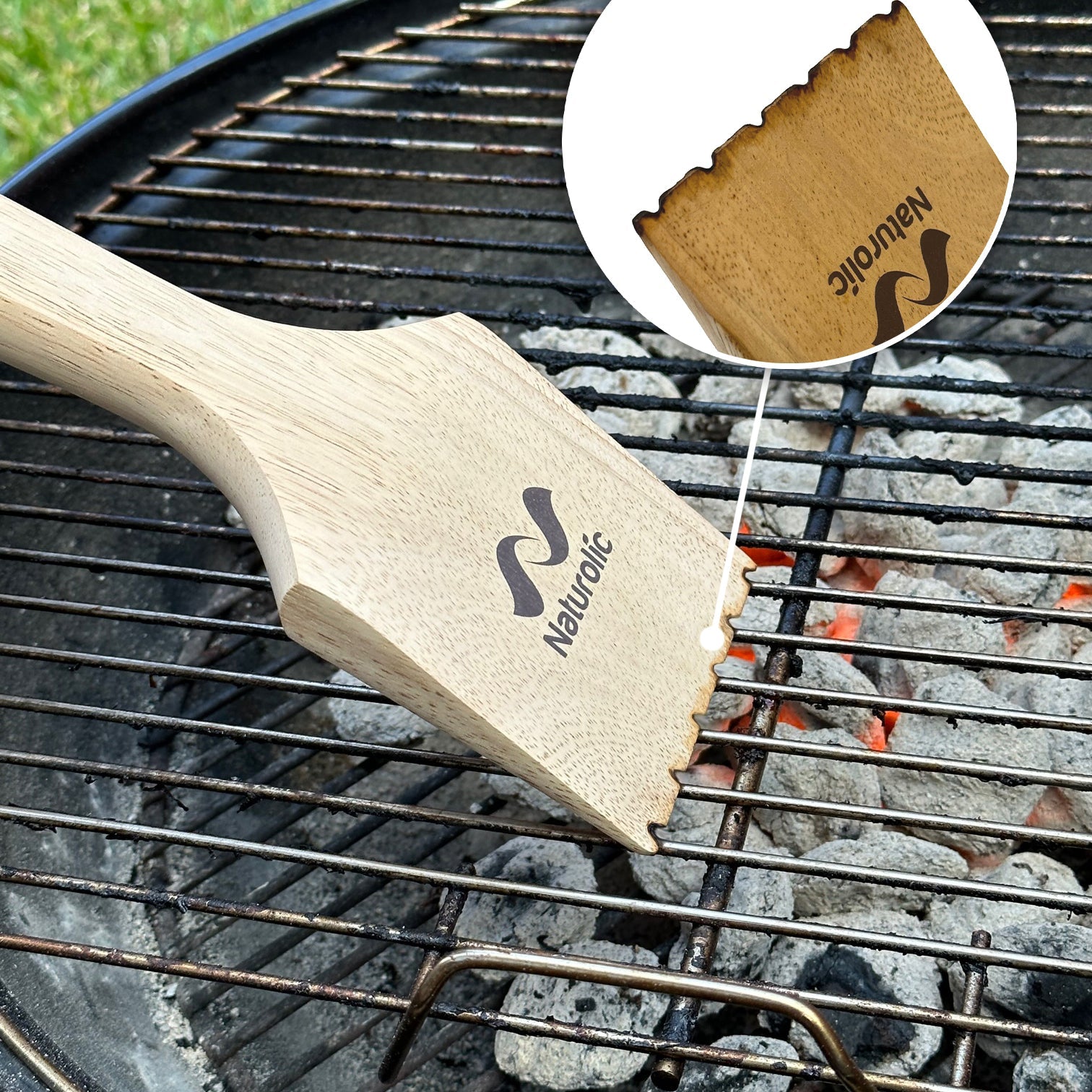 Wooden Grill Scraper 14” on a BBQ grill, showing its ergonomic design and natural wood finish.
